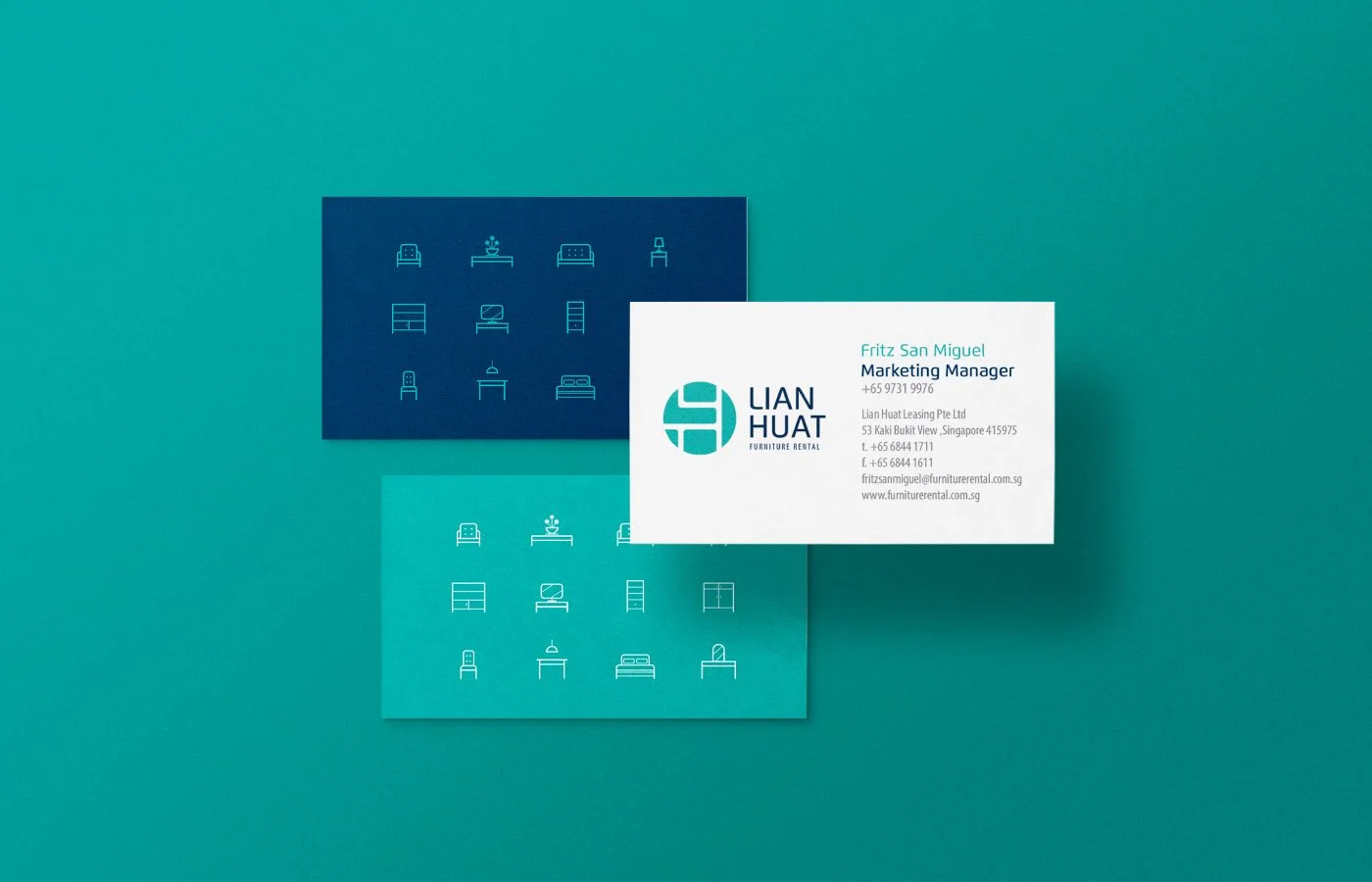 Business card for Lian Huat Furniture Rental, placed over patterned paper with furniture icons, on a green background.
