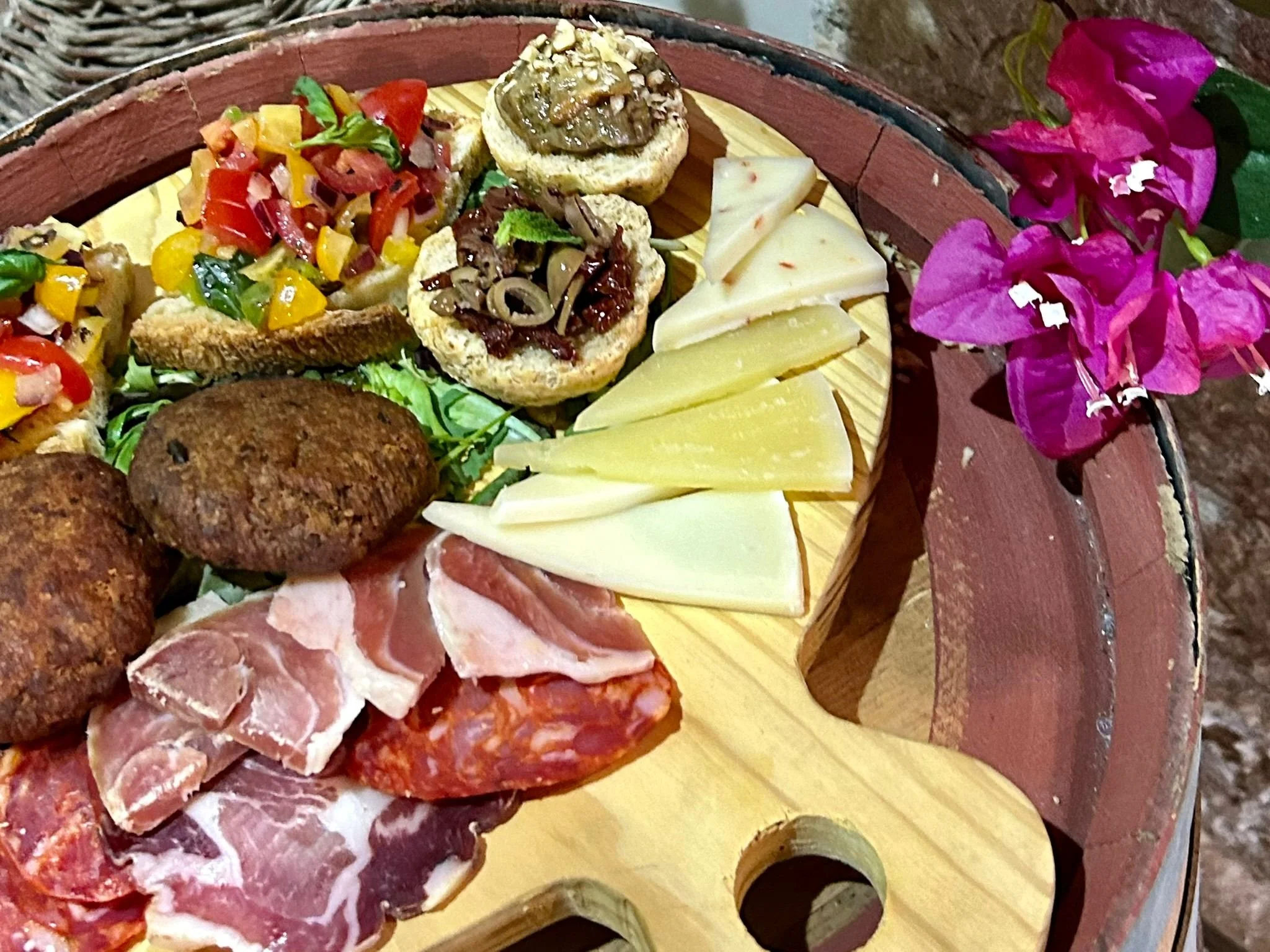 Un piatto di antipasti che include formaggi, salumi, crostini e bruschette