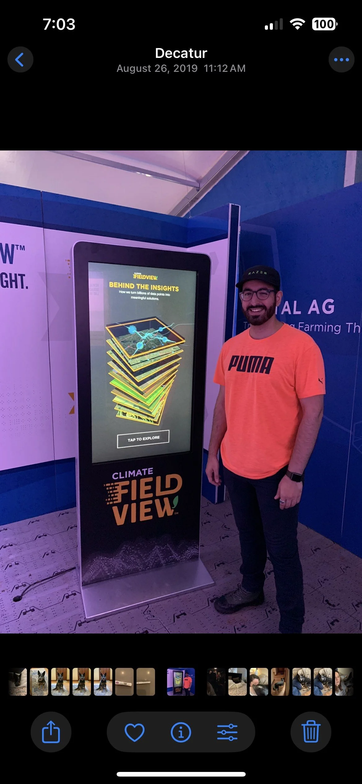 a smiling male standing by an interactive kiosk at an event