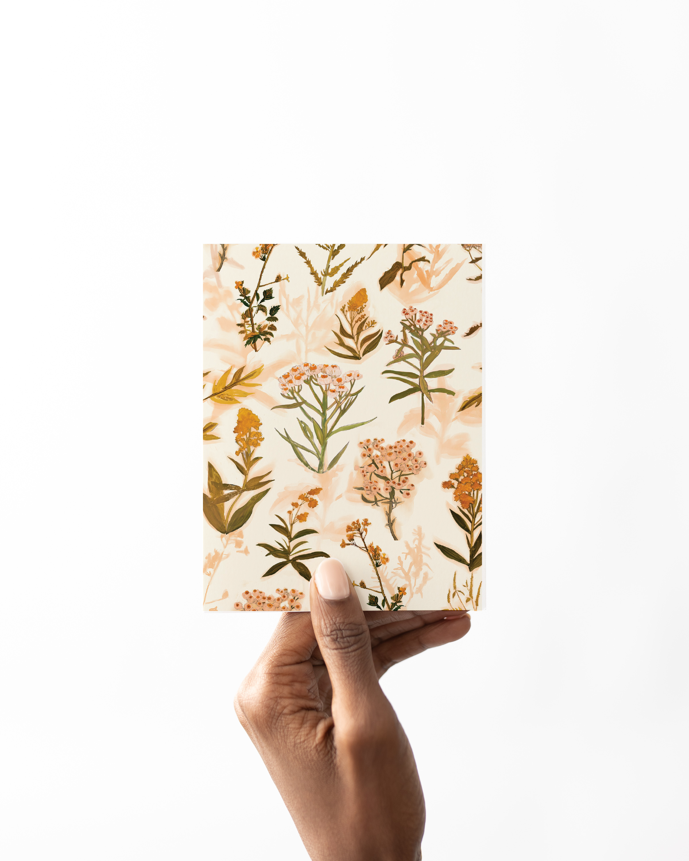 Greeting card with a repeating pattern of Sable Island wildflowers in soft ochre, peach, and gold tones on a cream background – artwork by Briana Corr Scott