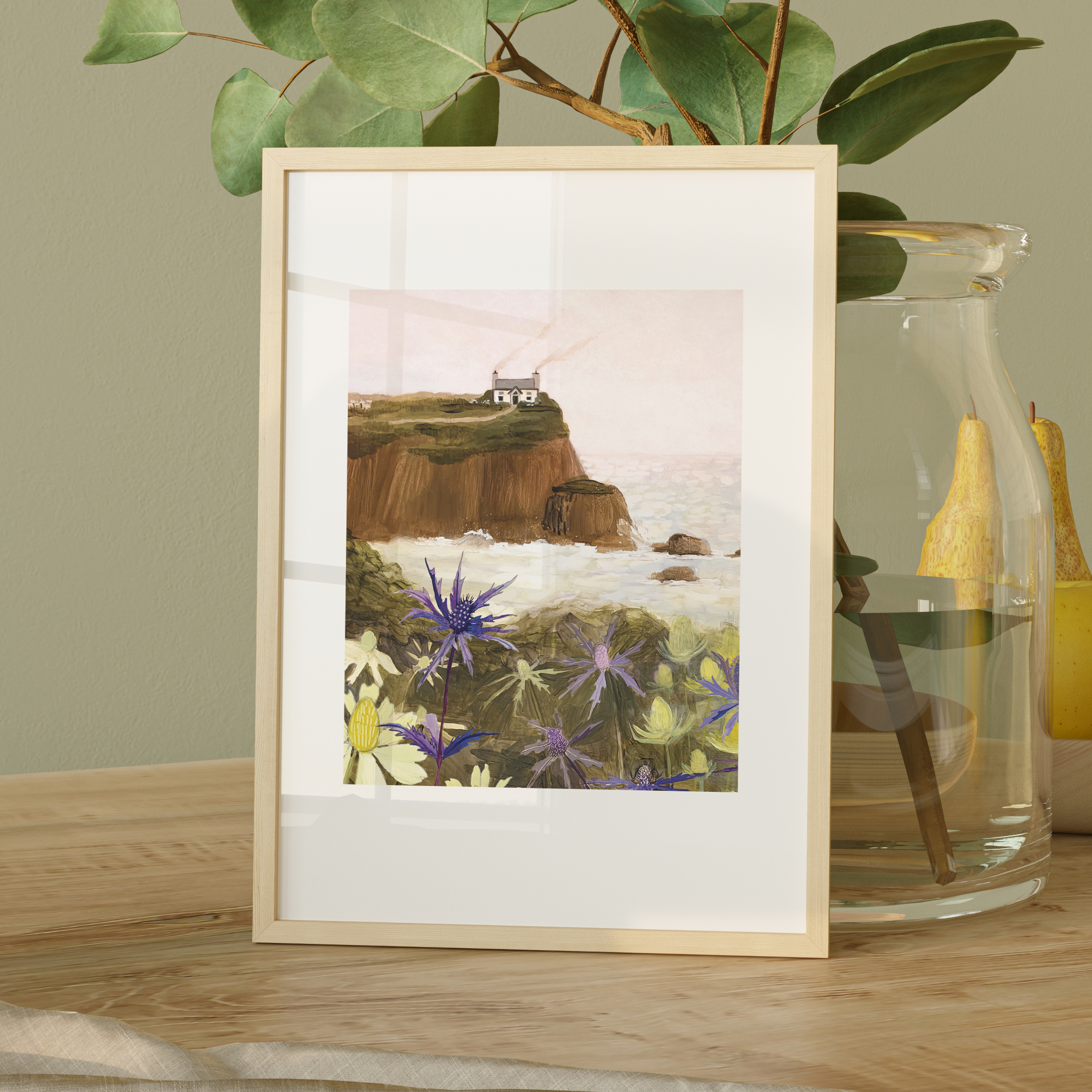 Gouache painting of a coastal cliff with a white house, sea holly flowers in the foreground, and waves crashing below – artwork by Briana Corr Scott