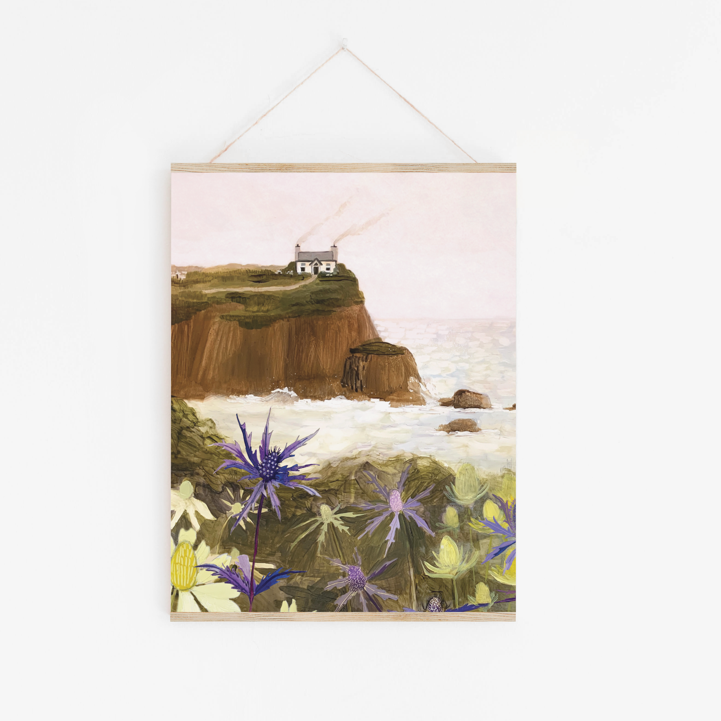 Gouache painting of a coastal cliff with a white house, sea holly flowers in the foreground, and waves crashing below – artwork by Briana Corr Scott