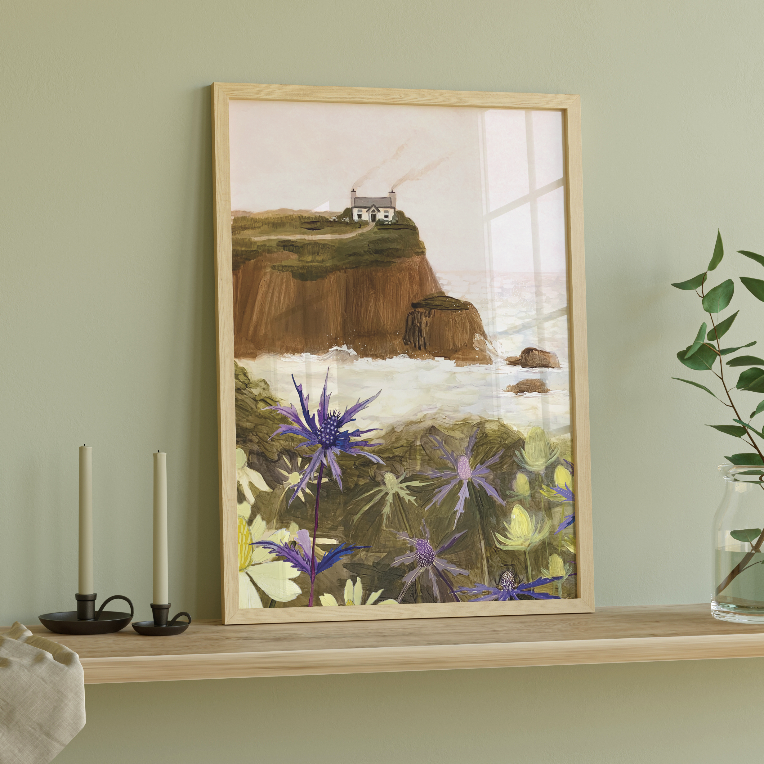 Gouache painting of a coastal cliff with a white house, sea holly flowers in the foreground, and waves crashing below – artwork by Briana Corr Scott