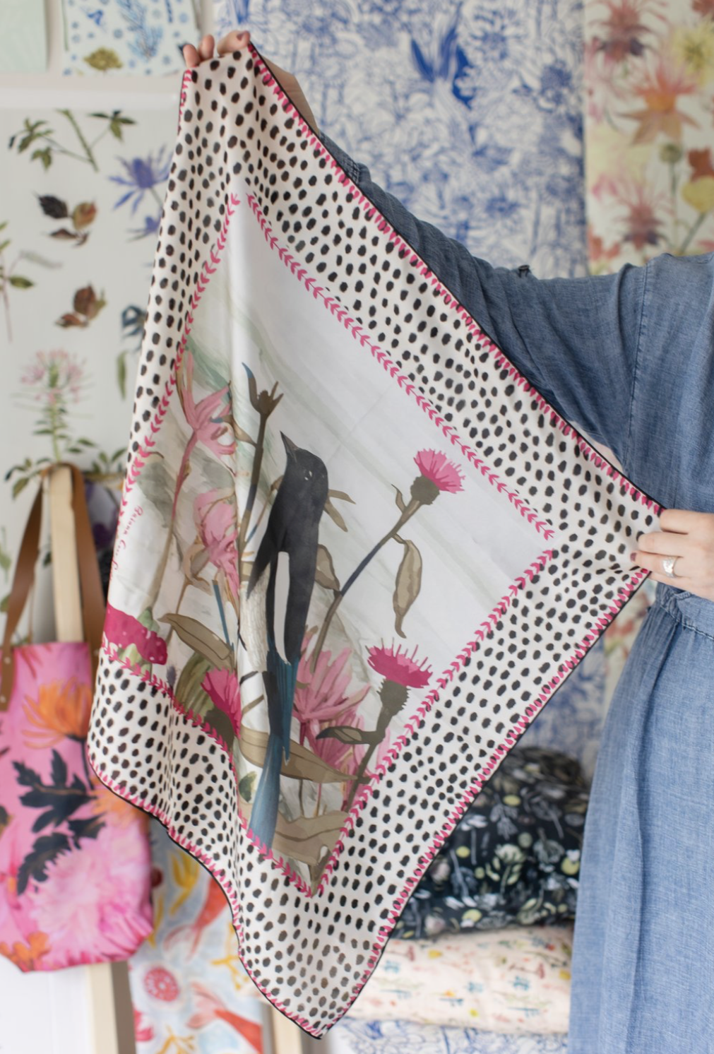 Square silk scarf with bright pink and red floral illustration on a soft background, designed by Briana Corr Scott and printed in Montreal, Canada.