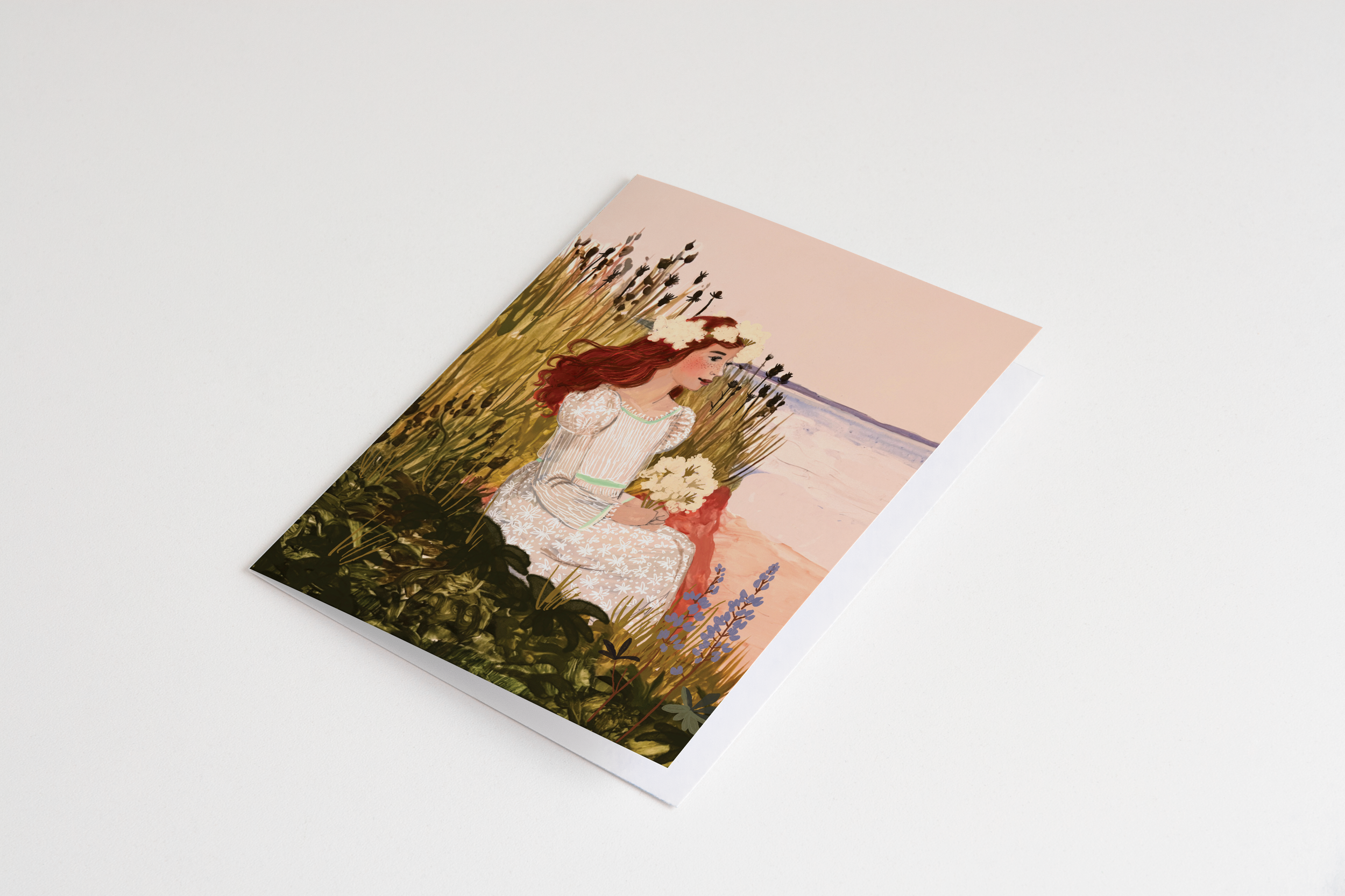 Anne of Green Gables sitting in a coastal meadow holding white flowers, wearing a floral dress and crown, with the sea in the background – artwork by Briana Corr Scott