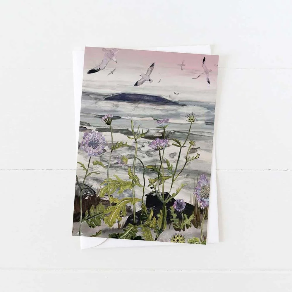 Greeting card featuring tall tangled wildflowers and weeds overlooking a grey coastal sea, with seagulls in flight and distant islands – artwork by Briana Corr Scott