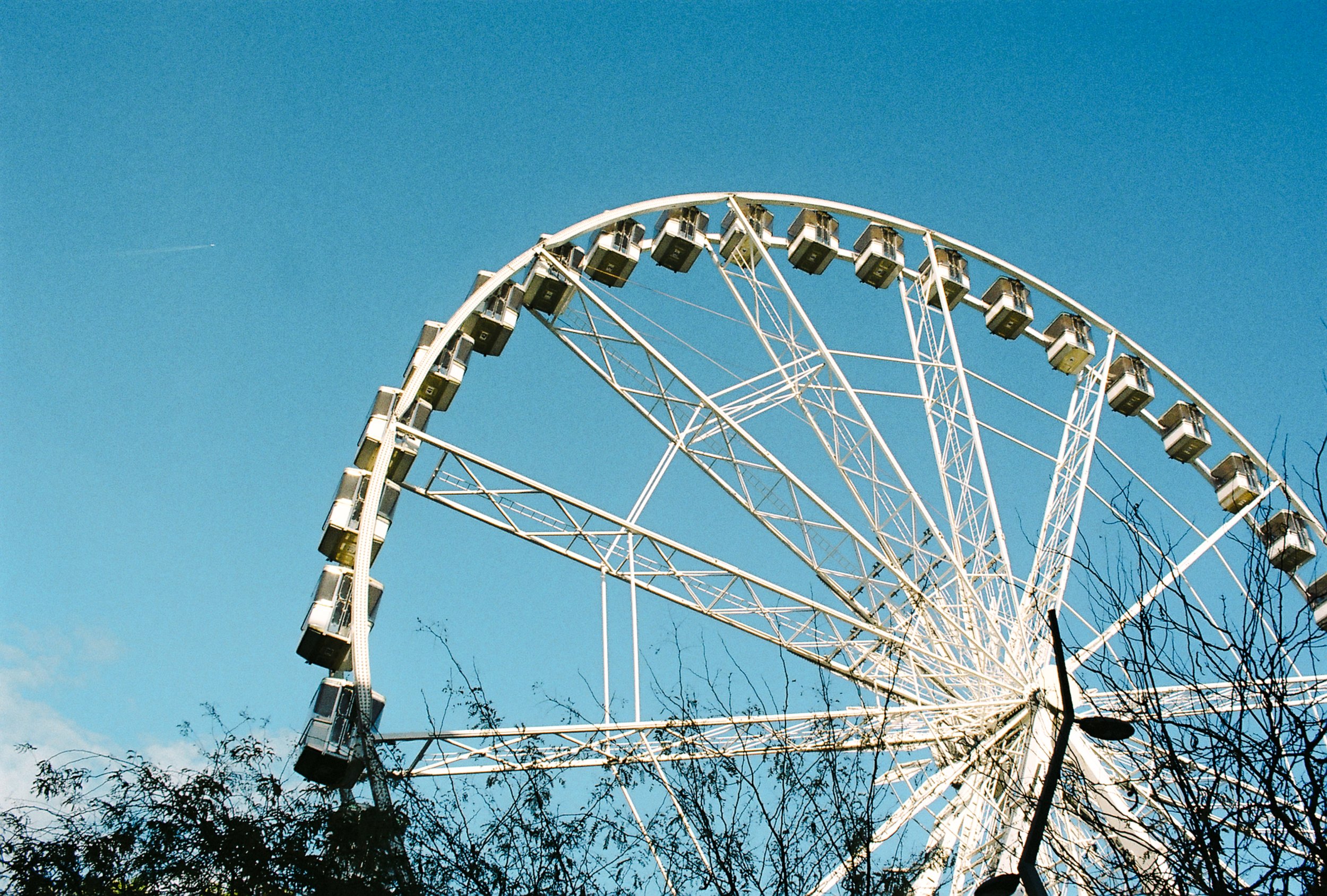 A large white Ferris wheel against a clear blue sky.