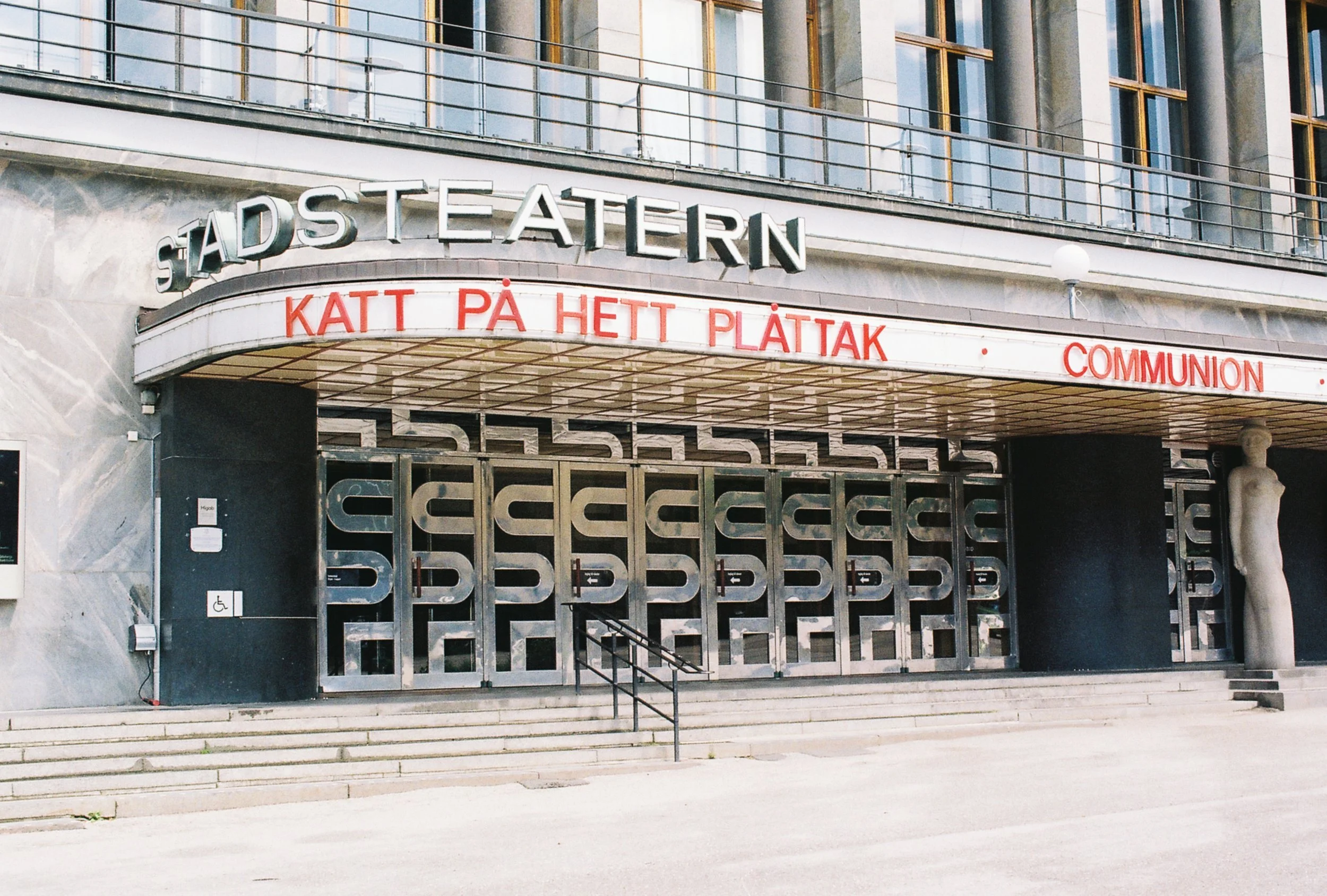 Entrance of Stadstheater with a sign in Swedish and a statue on the right side.