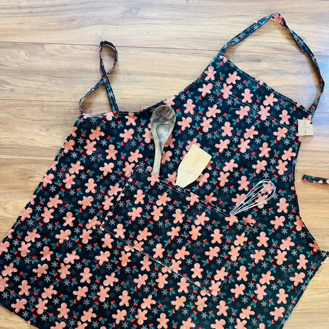 gingerbread print fabric on apron with cooking utensils in pocket