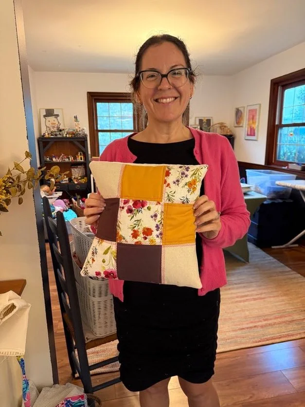 adult sewing class success, student holding patchwork pillow