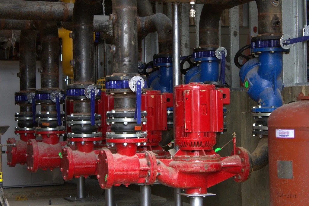 The entrance of EMCC with large glass doors and brick facade, illuminated with colorful interior lights visible inside.