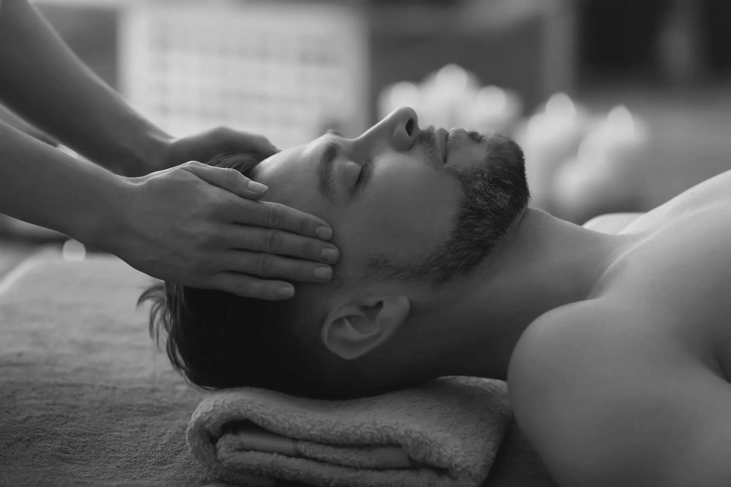 A man receiving a facial massage in a spa or massage setting.