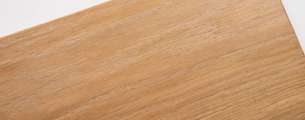 Nahaufnahme einer Holzplatte mit sichtbarer Maserung und glatter Oberfläche.