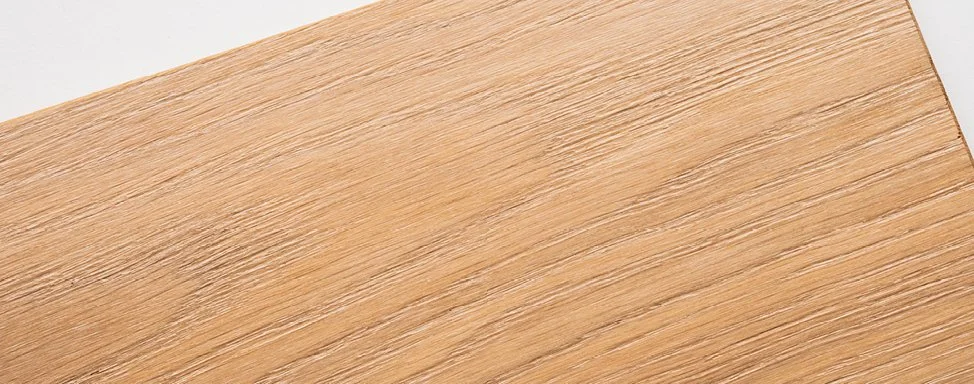 Nahaufnahme einer Holztischfläche mit sichtbarer Maserung.