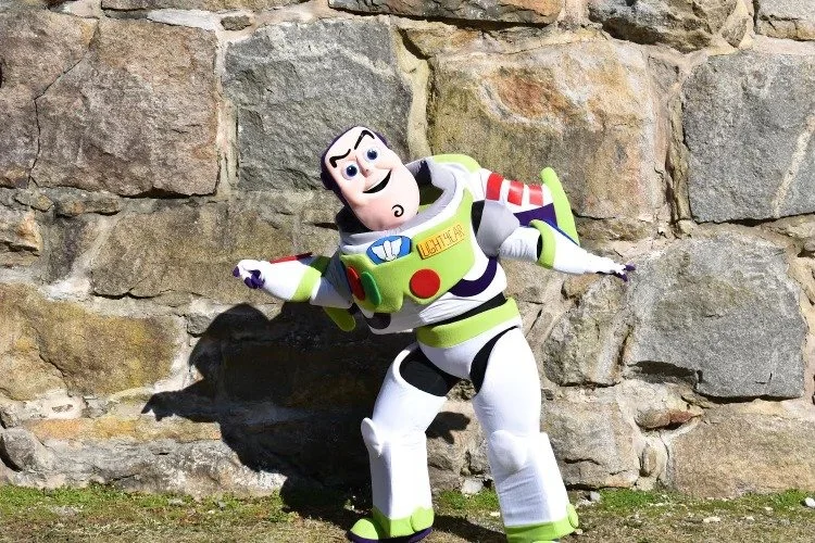 Inspired by Buzz Lightyear from Toy Story, leaning against a stone wall outdoors.