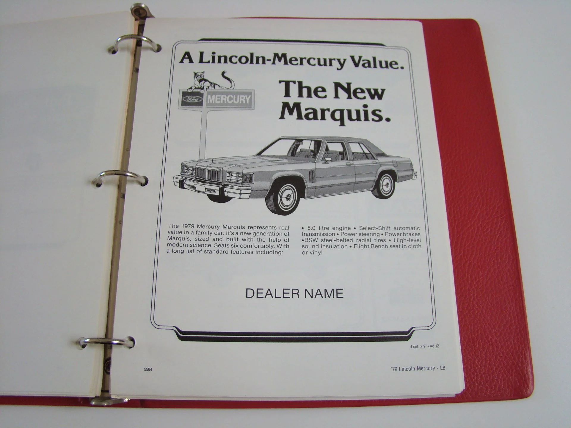 A printed advertisement for the 1979 Lincoln-Mercury Marquis, featuring a line drawing of the car and various specifications, with the title 'A Lincoln-Mercury Value. The New Marquis.' and space for dealer's name. The ad is in a binder with a red cov