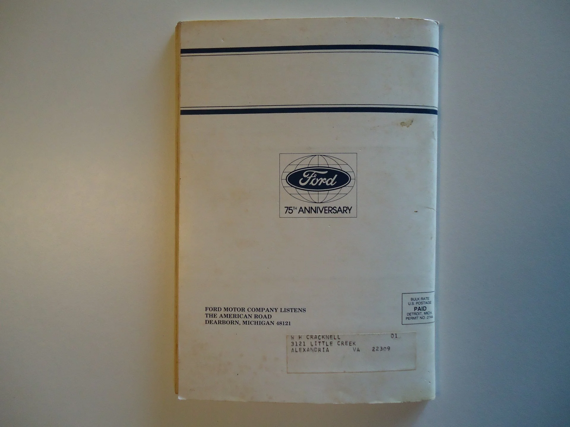 A vintage Ford booklet commemorating the company's 75th anniversary, with a postal label addressed to W H Cracknell in Alexandria, Virginia, set against a light-colored background.