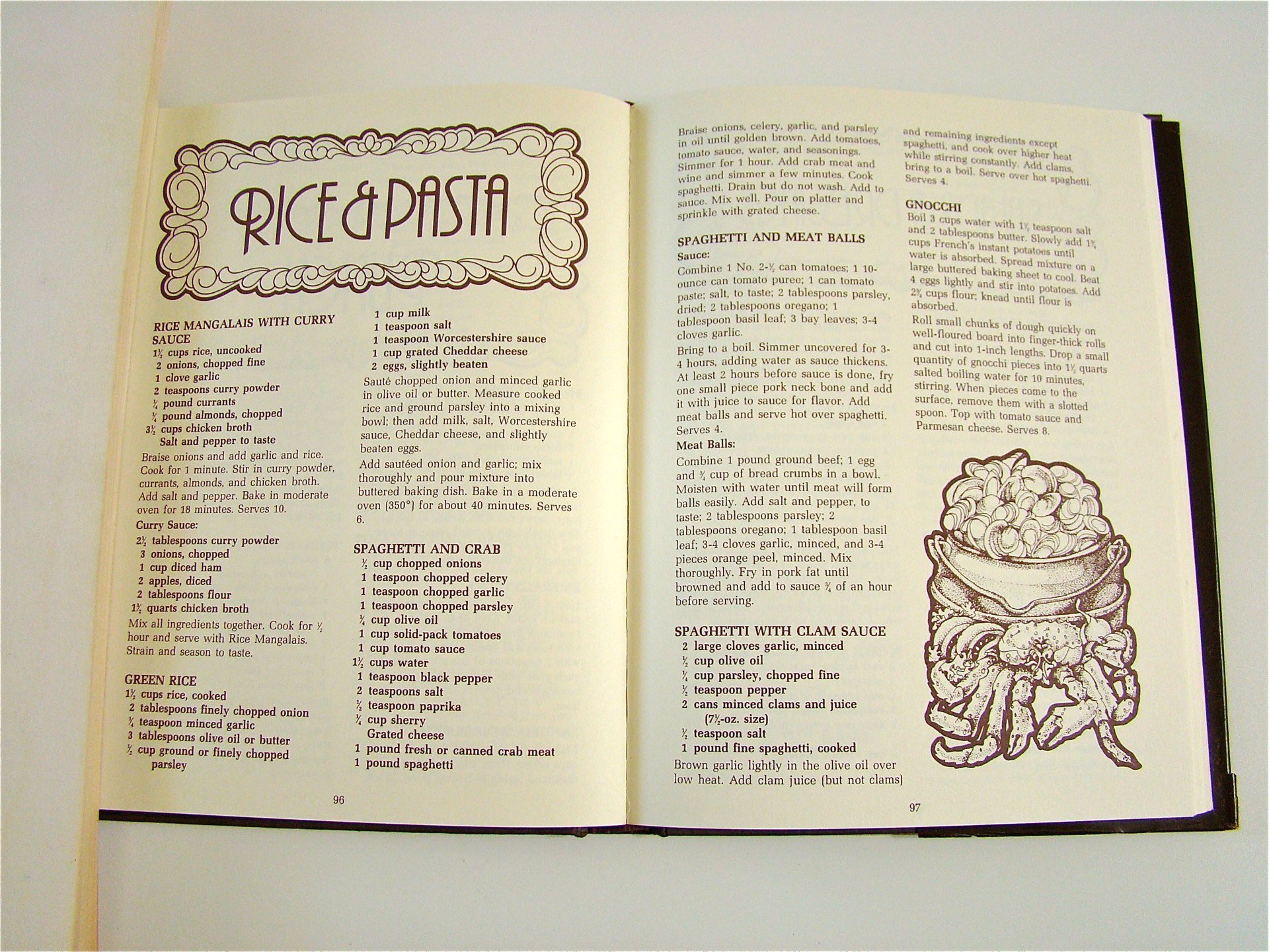Open cookbook showing recipes for rice and pasta dishes, including rice mangalais with curry sauce, curry sauce, spagheti and crab, spaghetti and meatballs, spaghetti with clam sauce, and green rice, with a drawing of a bowl of spaghetti topped with