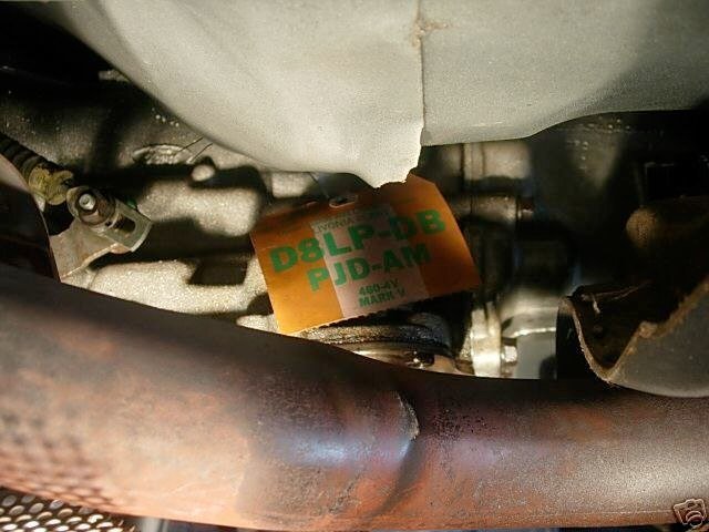Close-up view of a car engine showing a label with the text 'D&L PDB PUD-AM' attached to a component.