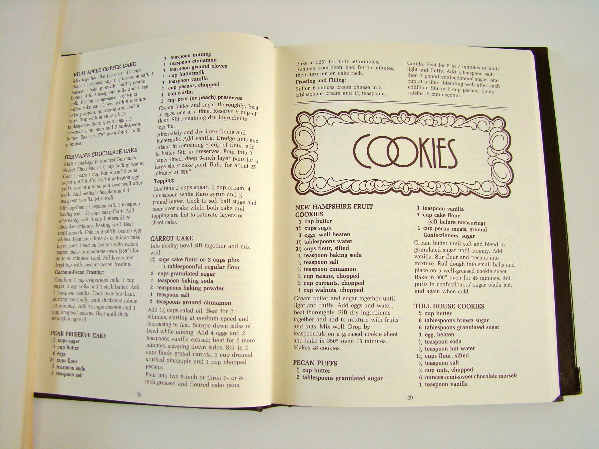 Open cookbook showing various cookie recipes, including Rich Apple Coffee Cake, German's Chocolate Cake, Carrot Cake, Pear Preserve Cake, New Hampshire Fruit Cookies, and Pecan Puffs.