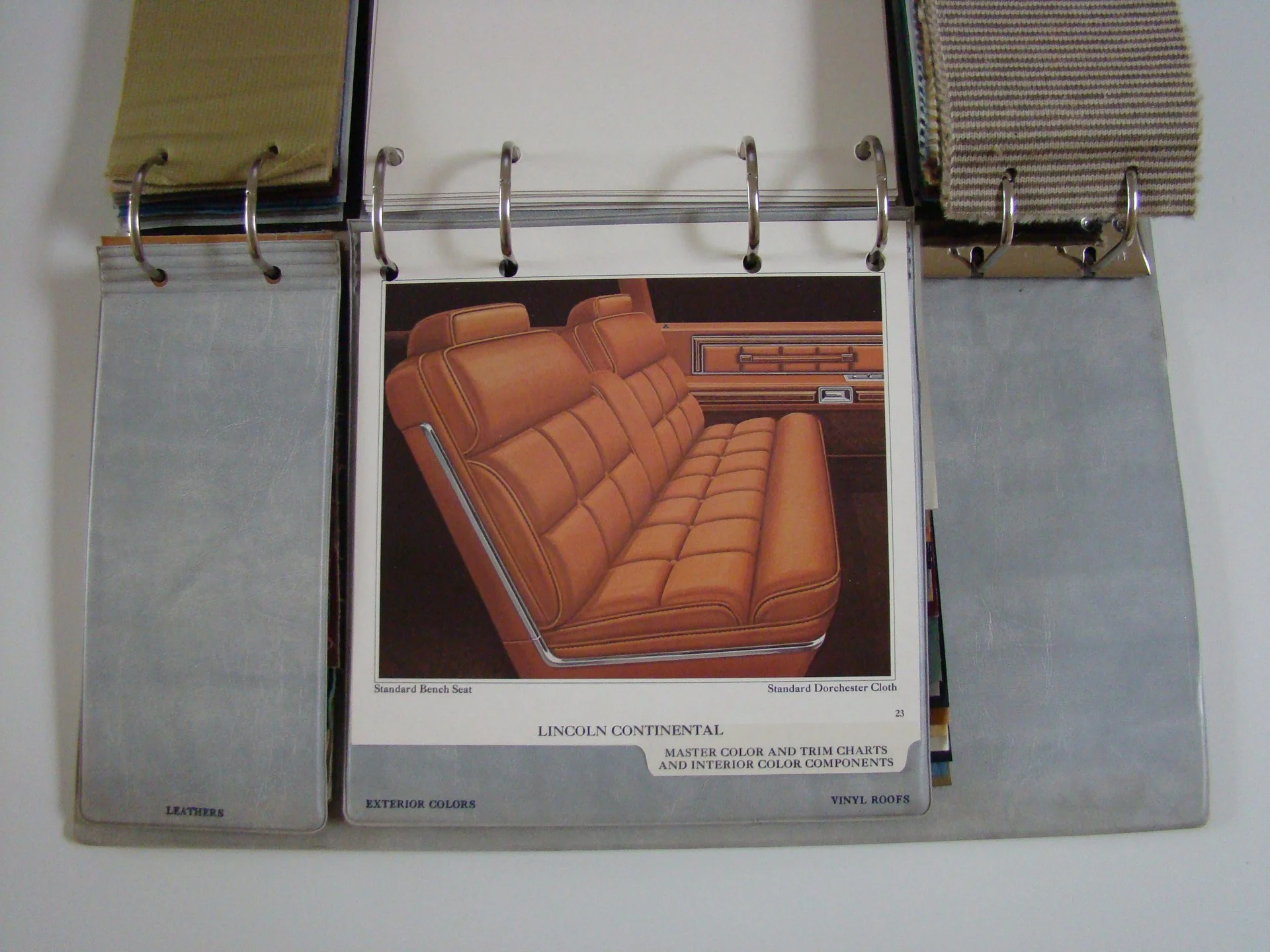 Color sample booklet open to a page showing a brown leather bench seat for a Lincoln Continental car.