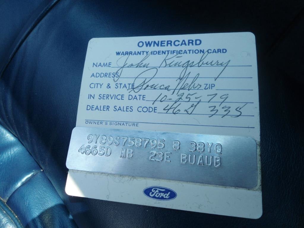 Owner's warranty card with handwritten owner information and a metal identification plate with vehicle details. The card shows the owner's name as Johny Kungsbury, address in Spraca, Nebraska, service date of October 25, 1979, and dealer code 462 3/5