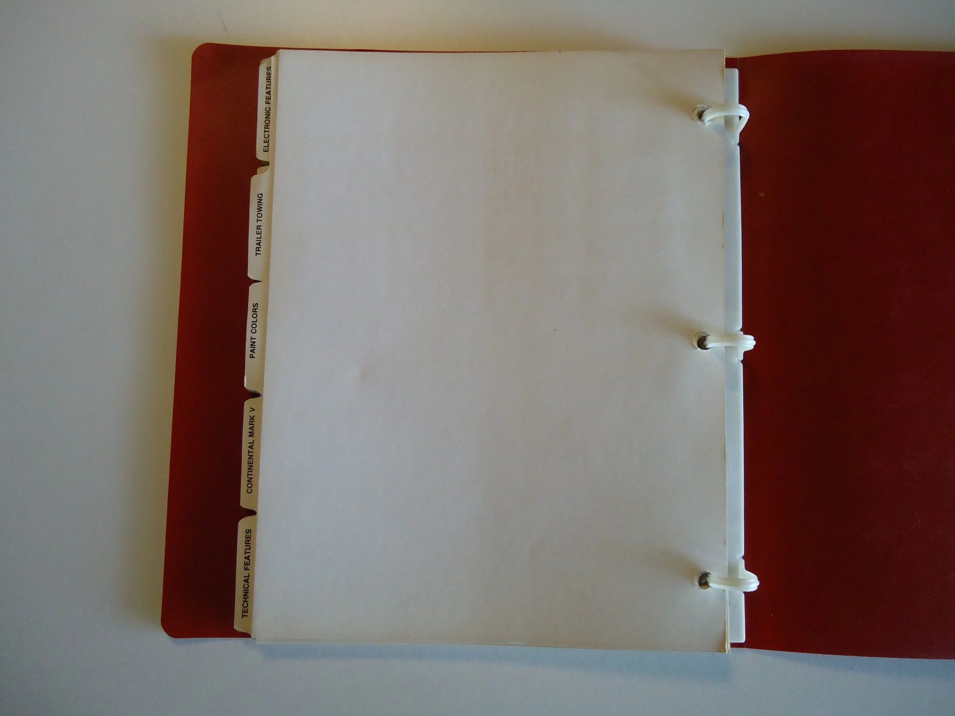 Open binder with tabbed dividers labeled 'Technical Features,' 'Continental Mark V,' 'Paint Colors,' 'Trailering,' 'Electronic Features' on the left side.