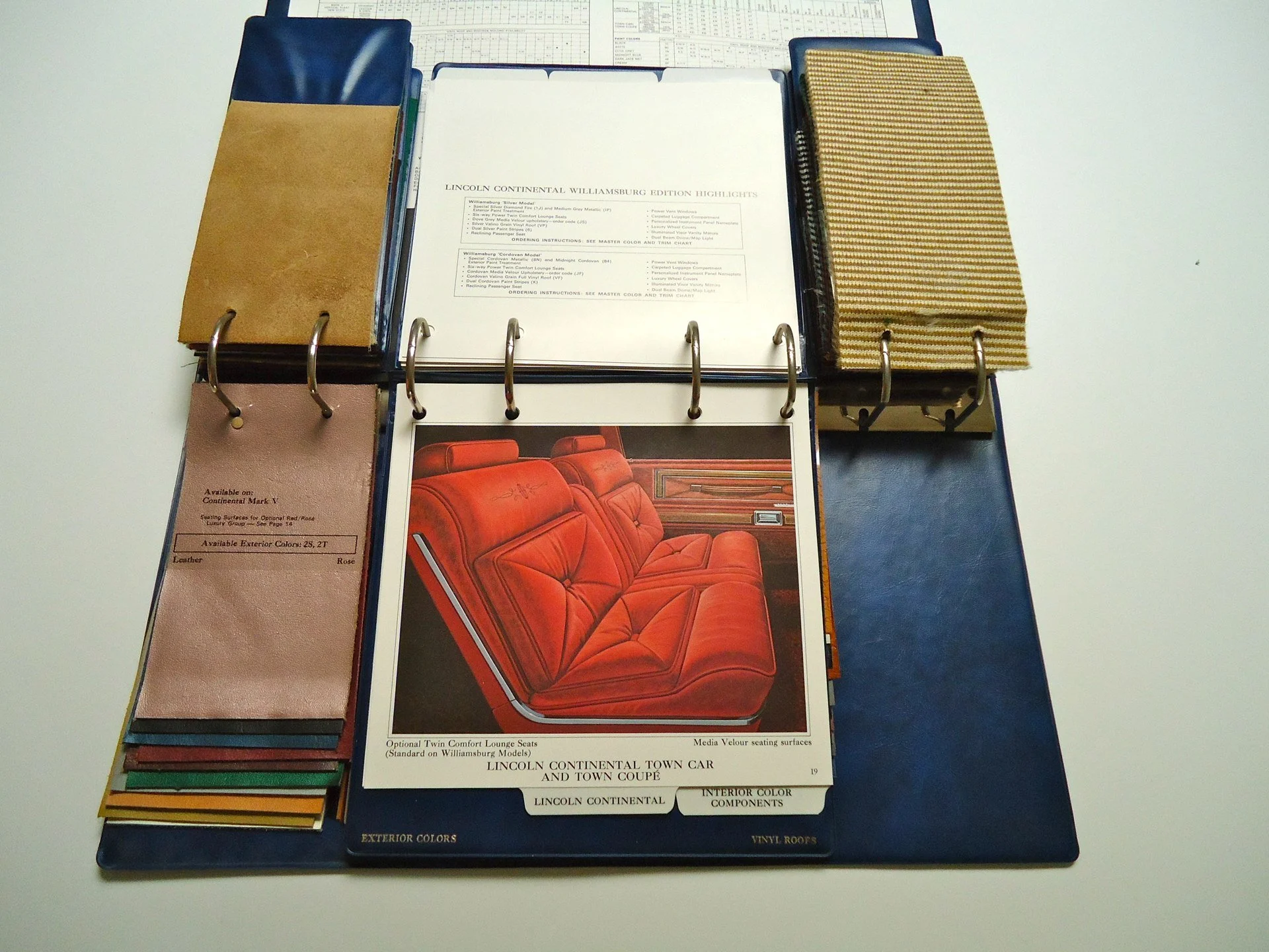 Car interior and exterior color sample book with fabric and material swatches for construction or automotive design.