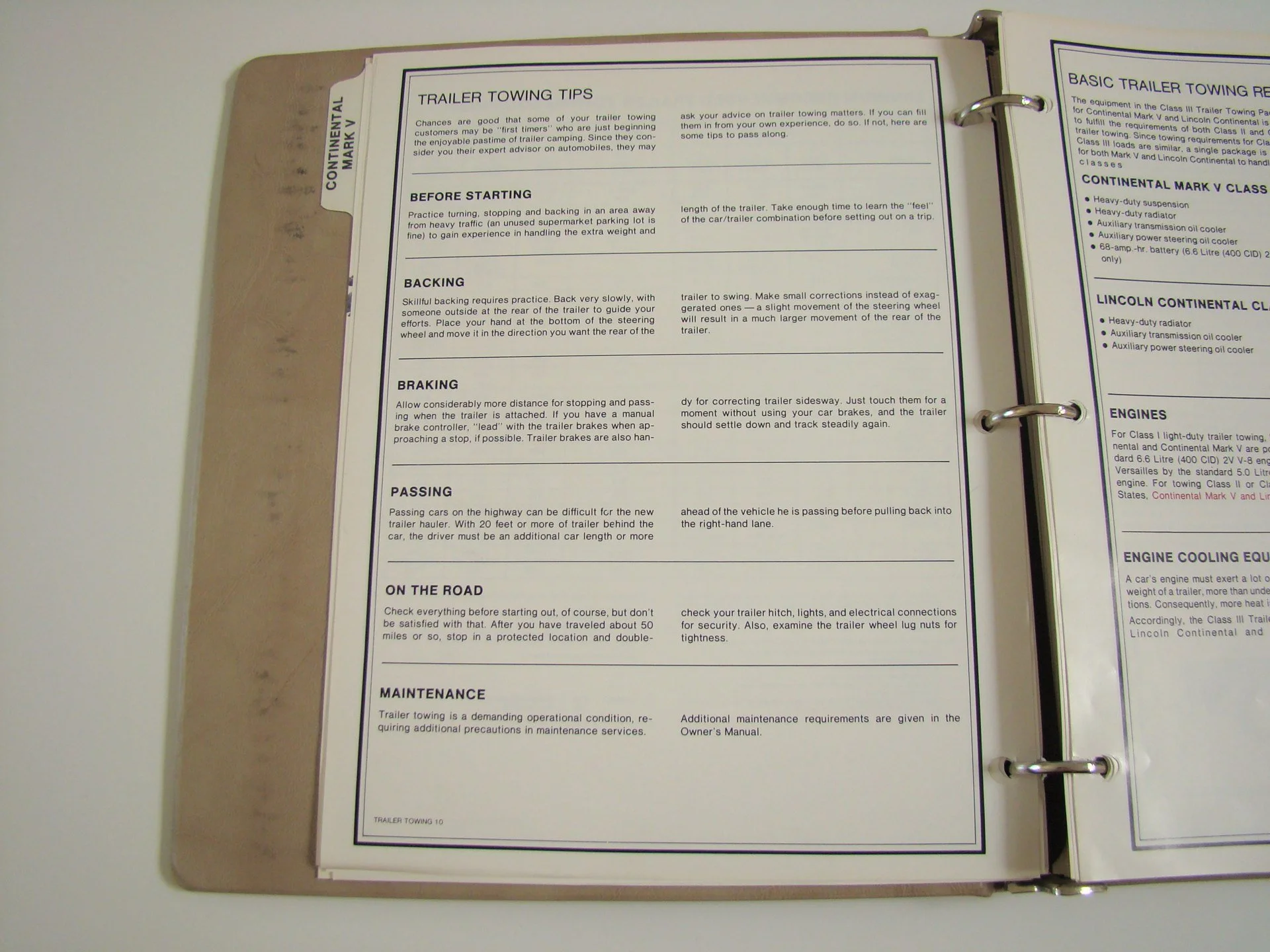 Open binder with two pages of trailer towing tips, including sections on backing, braking, passing, road safety, and maintenance, with text instructions and guidelines.