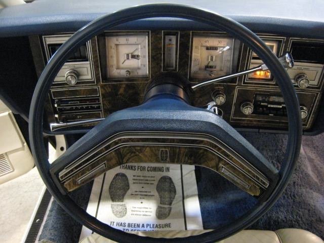 Dashboard of a vintage vehicle with a steering wheel, speedometer, and other gauges, viewed from the driver's seat