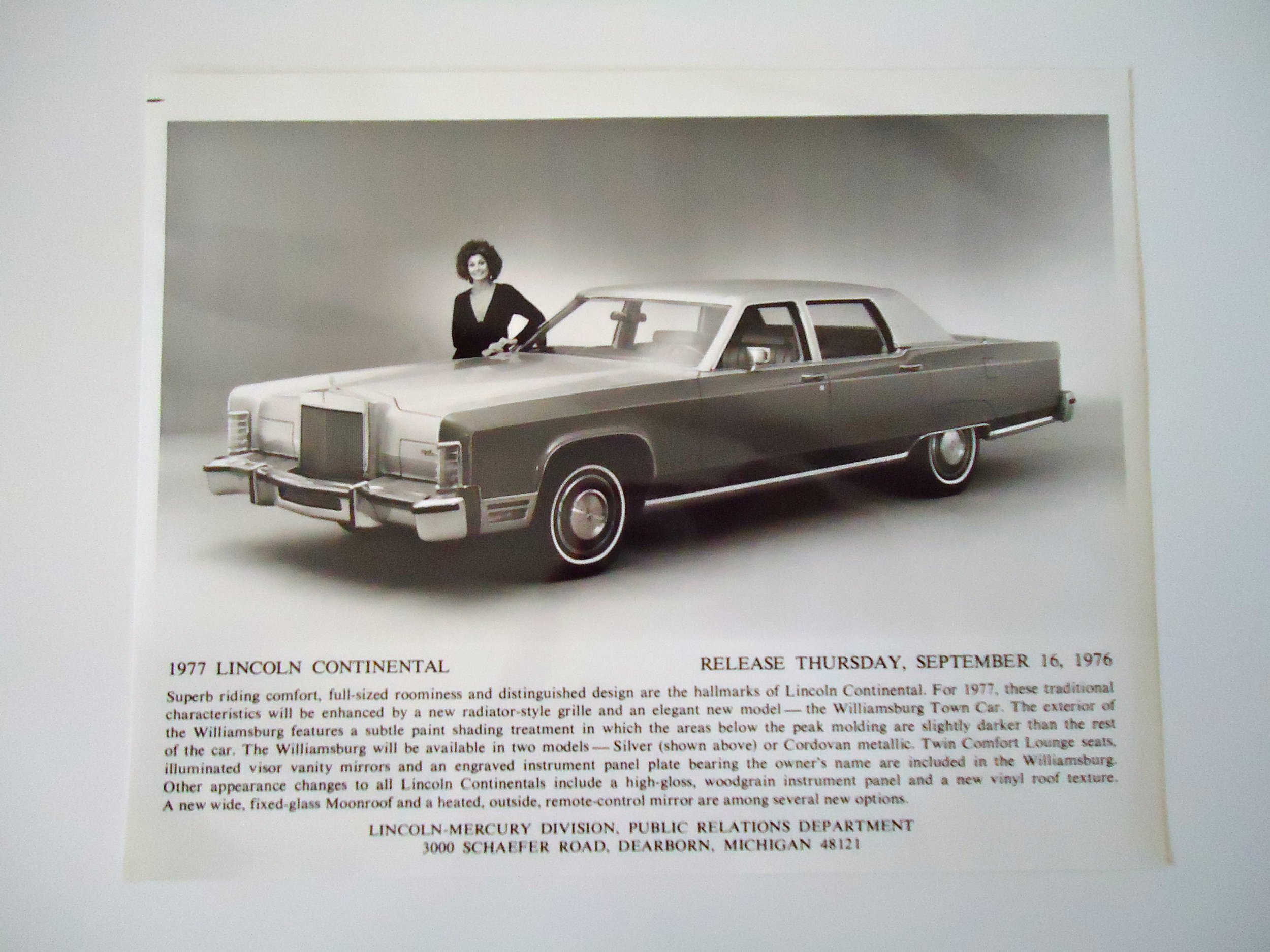 Black and white advertisement for the 1977 Lincoln Continental, showing a woman standing beside a large, vintage luxury car.
