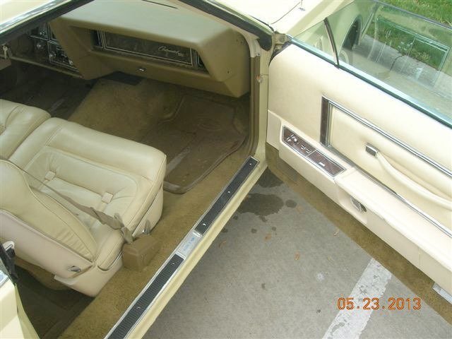 Interior of a vintage cream-colored car, showing the front passenger seat and dashboard with various controls, dated May 23, 2013.