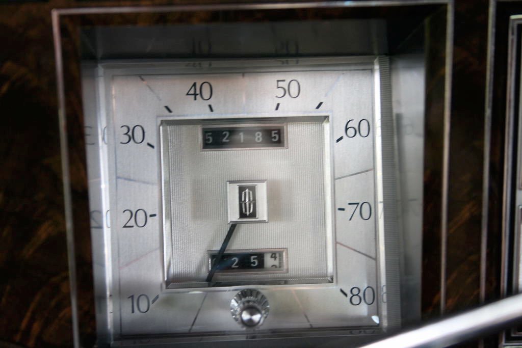 Close-up of a vintage car speedometer showing a speed of approximately 22 mph, with an odometer reading 52185 miles.