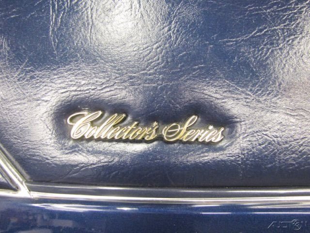 Close-up of a metallic emblem reading 'Collector's Series' on a dark, textured surface, likely a vehicle interior or exterior.