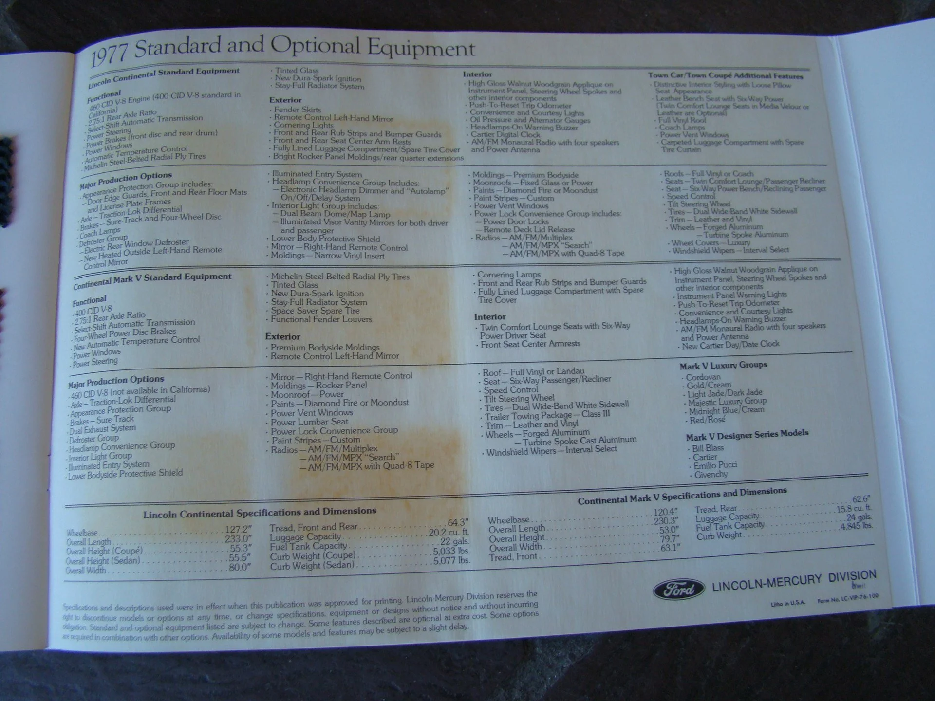 A page from a 1977 Ford Lincoln-Mercury brochure listing standard and optional equipment for Lincoln Continental and Mark V models, including features such as engine options, exterior and interior features, and dimensions.
