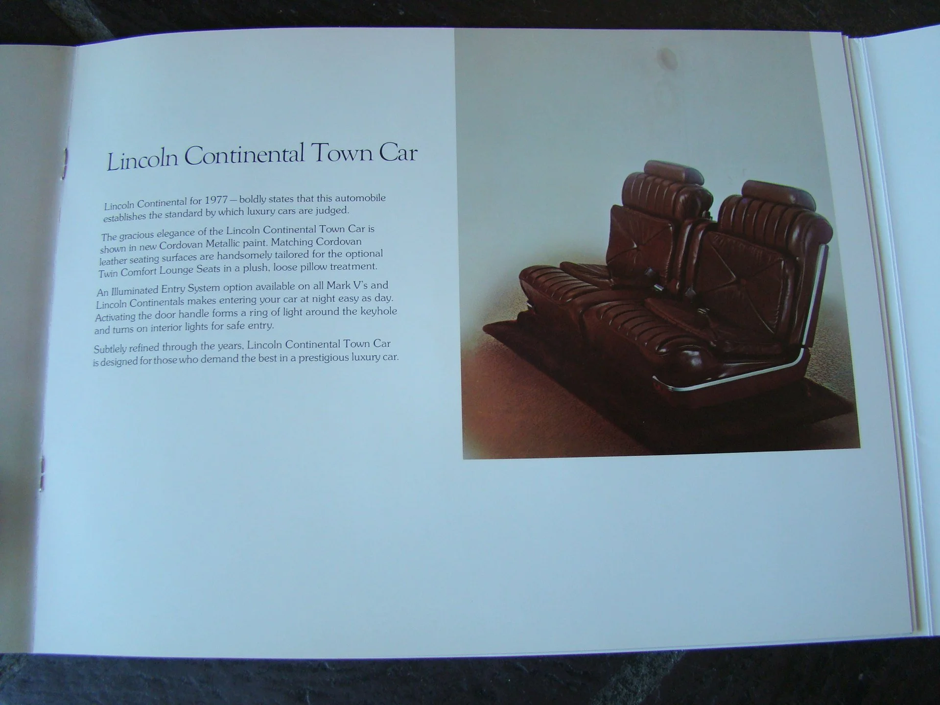 Page from a brochure describing the Lincoln Continental Town Car, featuring a photograph of a vintage dark red leather car seat with ribbed and diamond-stitched detailing.