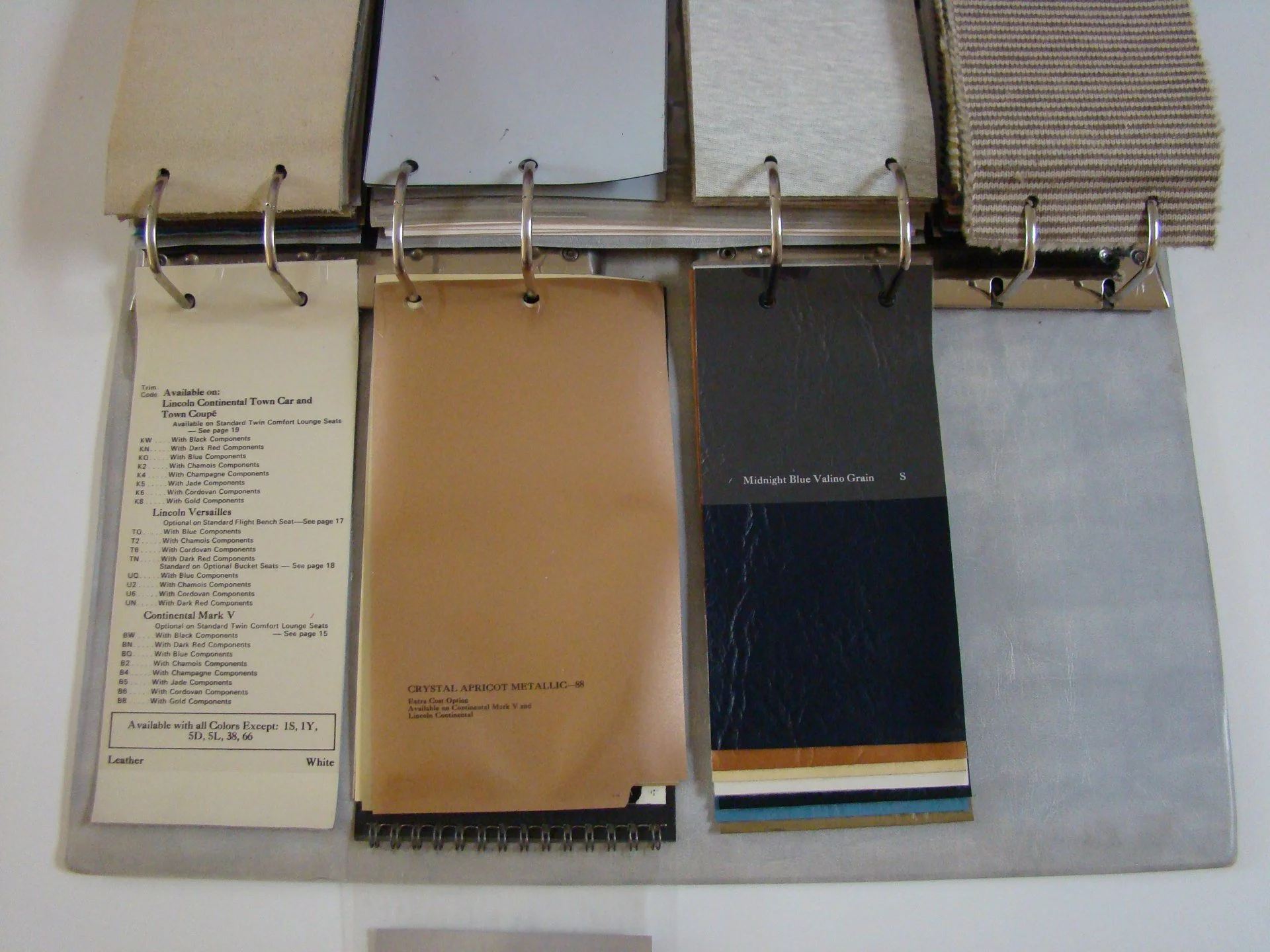 Sample display of color and fabric swatches on a binder with fabric samples in various shades and textures.