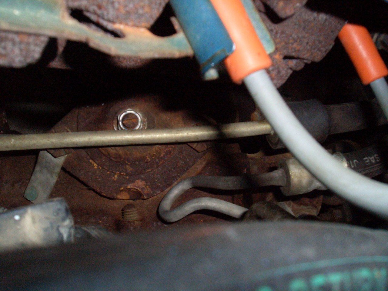 Close-up view of a rusty engine with metal pipes and components.