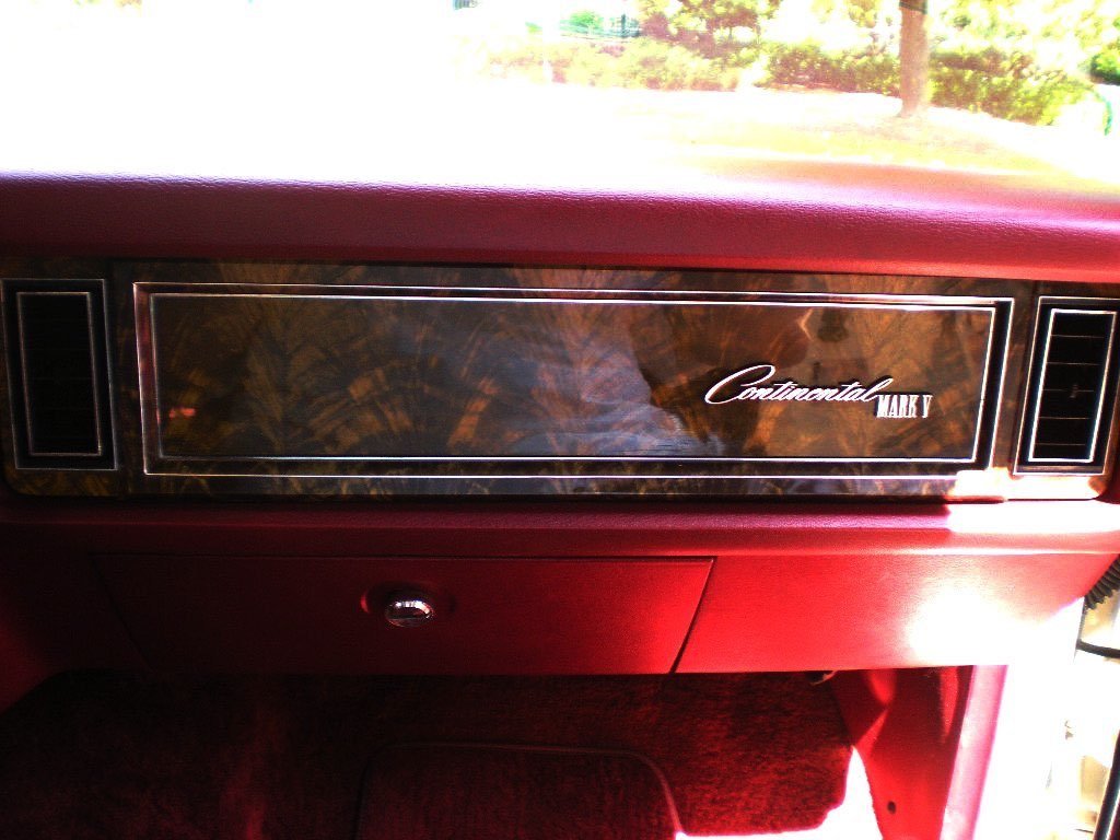 Dashboard of a vintage car with the label 'Continental Mark V' in wood grain and black accents.