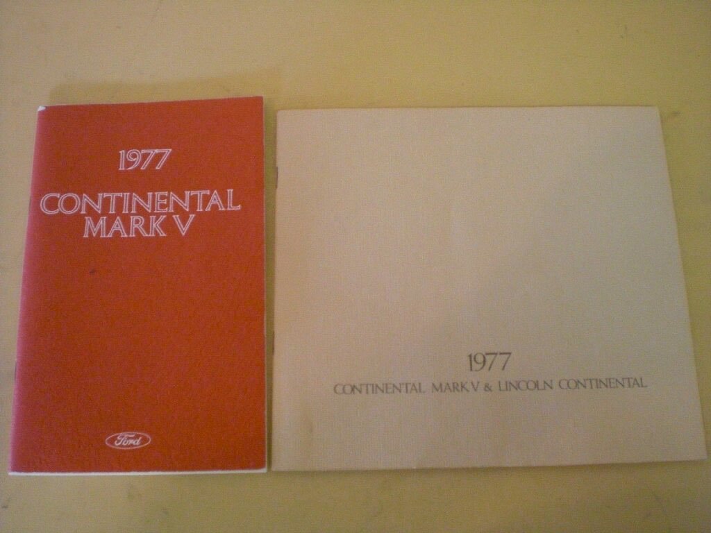 Two vintage car brochures, one red titled "1977 Continental Mark V" and one white titled "1977 Continental Mark V & Lincoln Continental".