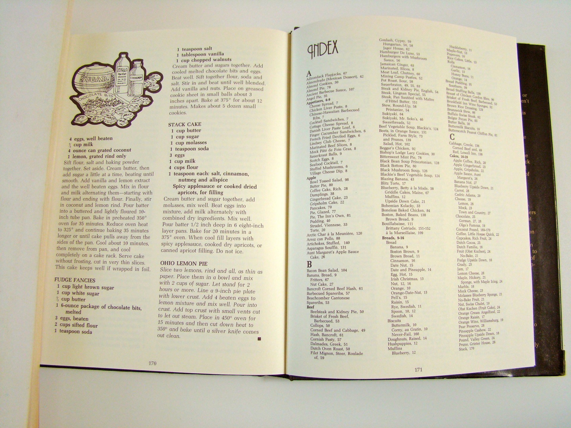 Open cookbook showing recipes for baked goods, including stack cake, Ohio lemon pie, and fudge fancies, with text and illustrations.
