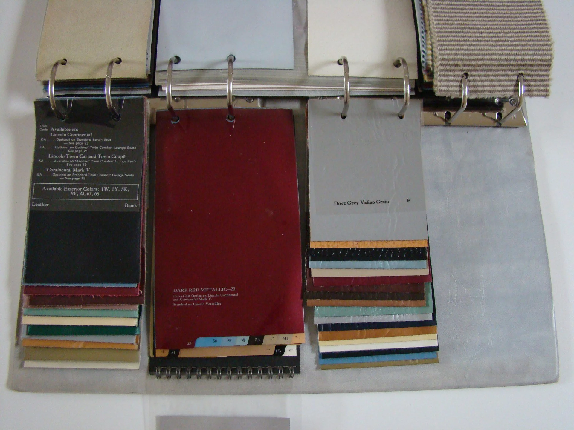 Open sample book with fabric swatches and paint color samples in a binder.