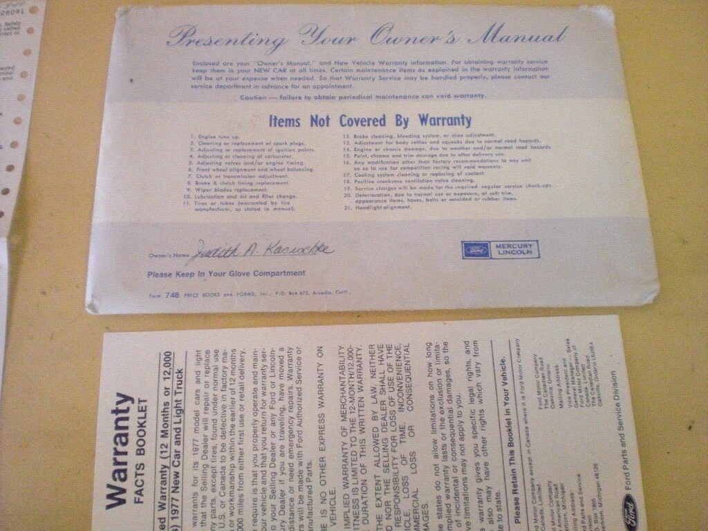 A Ford owner's manual and warranty booklet on a table.