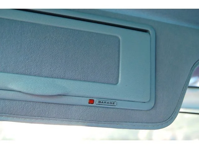 Inside view of a car's overhead console with a small label that says 'Garage' and a red indicator light.