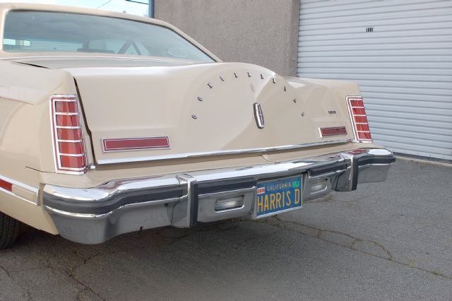 Rear of a vintage cream-colored car with a California license plate reading 'HARRIS D' and the word 'Cadillac' spelled out on the trunk
