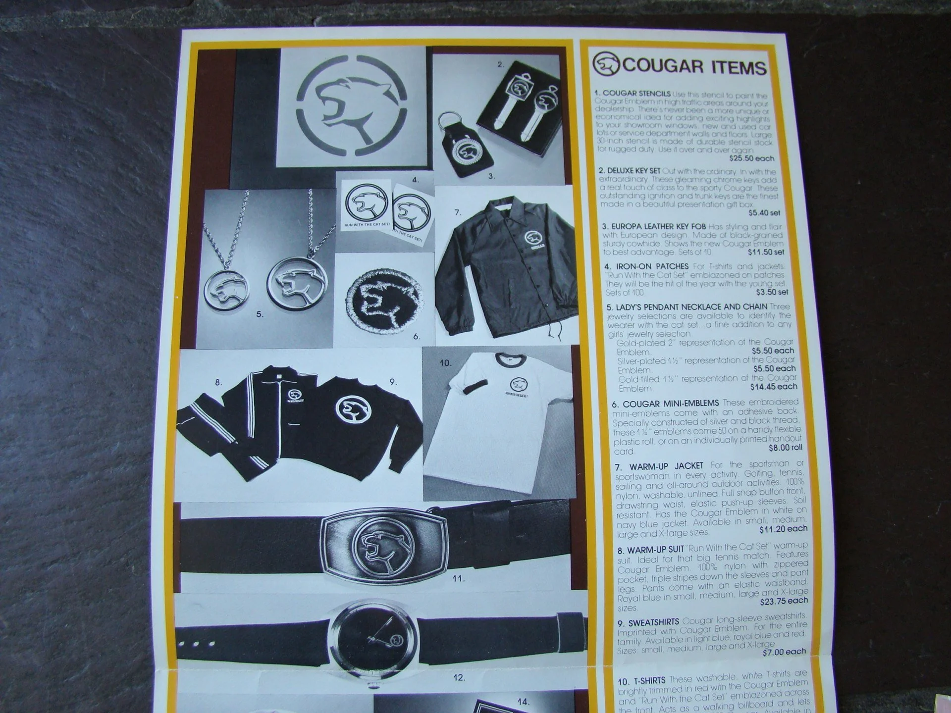 Image of a catalog page showcasing Cougar brand items, including stencils, key sets, patches, jackets, belts, sweatshirts, and T-shirts, with descriptions and prices for each item.