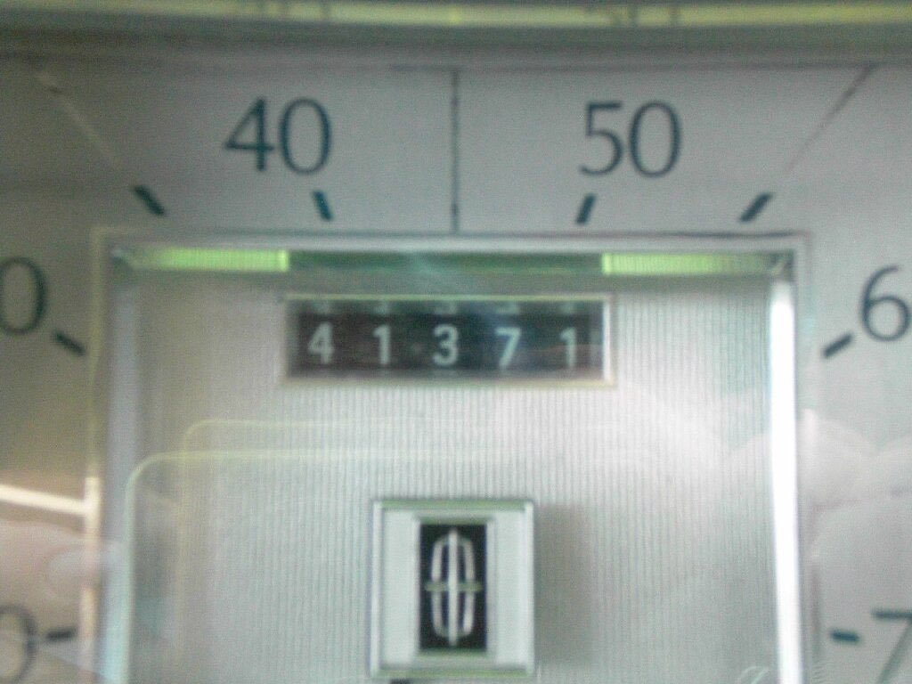 Close-up photo of a vintage analog meter, with a central display showing the numbers 41371 and a scale marked from 0 to 60 with green indicator lights near 40 and 50.