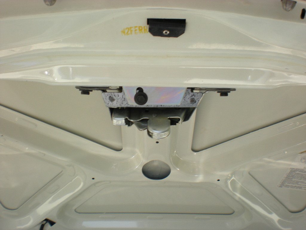 View of the inside of a vehicle's trunk or hood showing a latch or locking mechanism.
