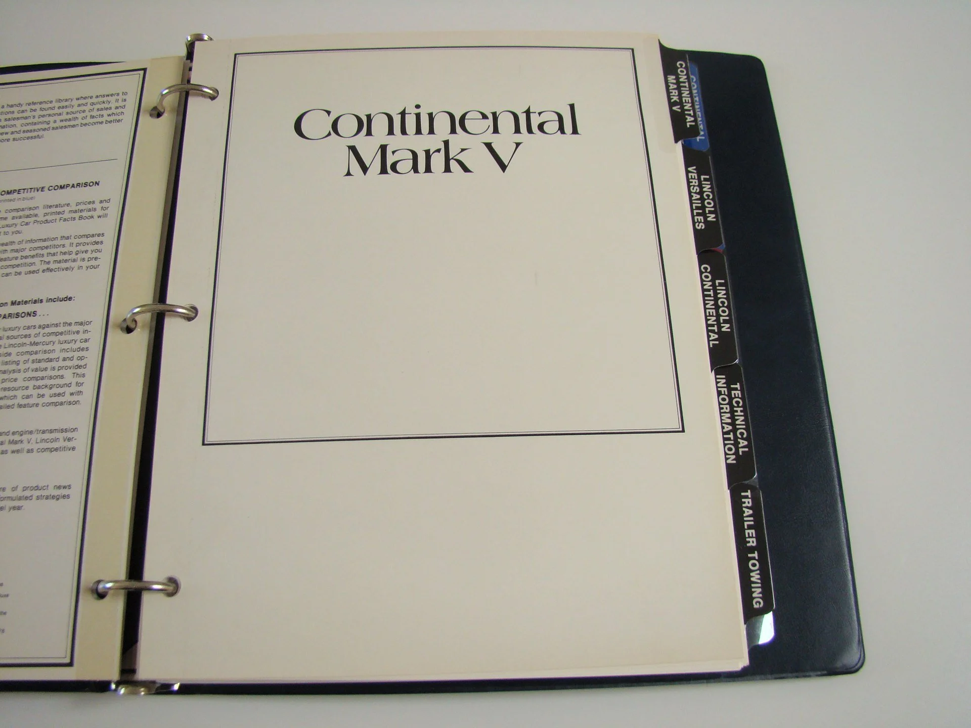 Open binder with tabs labeled Lincoln Versailles, Lincoln Continental, Technical Information, Trailer Towing. The page on the binder is titled 'Continental Mark V'.