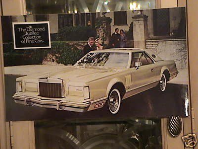A vintage beige luxury car parked outside a stone building with a sign that reads 'The Diamond Jubilee Collection of Fine Cars'.